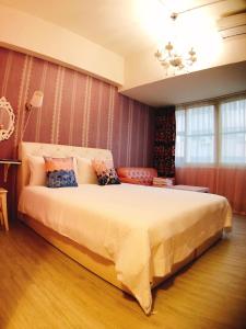 ein Schlafzimmer mit einem großen Bett in einem Zimmer in der Unterkunft Traveler Station R15 in Kaohsiung
