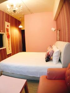 Habitación de hotel con 2 camas y sofá en Traveler Station R15, en Kaohsiung