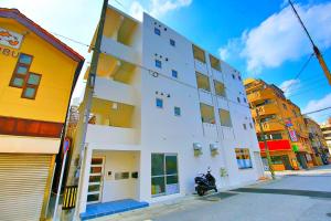 a white building on the side of a street at Matsufuji 2F in Naha