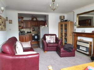 een woonkamer met 2 rode stoelen en een koelkast bij Lyndale Family Apt Winter Deals offered on 3 nts or more in Windermere