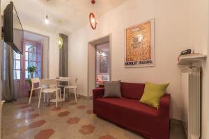 Una sala de estar con un sofá rojo y un comedor. en Colosseum Lovely Apartment, en Roma