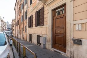un edificio con una puerta de madera en el lateral de una calle en Colosseum Lovely Apartment, en Roma