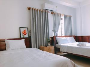 a bedroom with two beds and a window at VIỆT Hostel in Hue