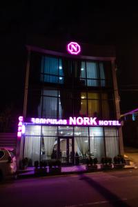 un concessionnaire de voitures en couronne avec un signe néon sur celui-ci dans l'établissement Nork Hotel, à Erevan