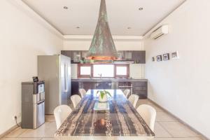 una cocina con una mesa con sillas y una lámpara. en AB Villa & Apartments, en Seminyak