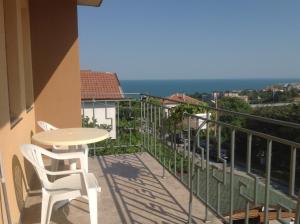 balcón con mesa, sillas y vistas al océano en Villa Omiros, en Byala