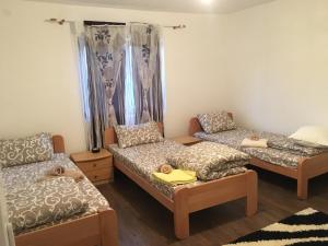 Cette chambre comprend trois lits et un canapé. dans l'établissement Apartmani ,,Bato,,, à Sjenica