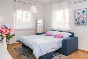 a bedroom with a blue bed with pink pillows at Apartment Pula Relax in Pula