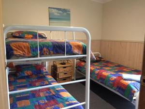 a bedroom with two bunk beds in a room at Mallacoota Log cabins in Mallacoota