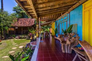 a patio of a house with a wooden roof at Villa Melasti Amed in Amed
