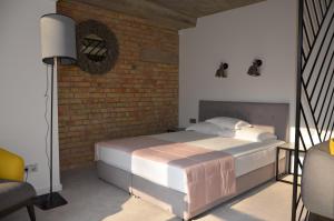 a bedroom with a bed and a brick wall at StanGret Hotel in Kyiv