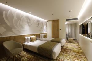 a hotel room with two beds and a chair at Effotel by Sayaji Vadodara in Vadodara +43 photos