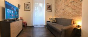- un salon avec un canapé et un mur en briques dans l'établissement Appartamento in via Licia, à Rome