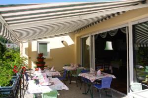 a patio with tables and chairs on a balcony at Hotel Restaurant des Deux Vallées in Entraygues-sur-Truyère