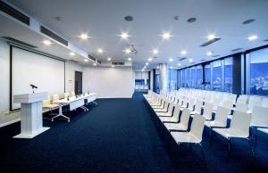 a conference room with white desks and white chairs at King David Residence in Tbilisi City