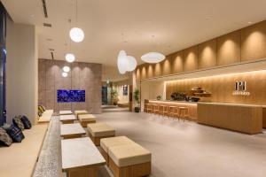 a lobby of a restaurant with benches and a counter at hotel MONday Premium TOYOSU in Tokyo