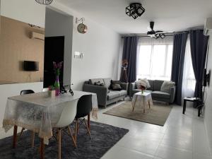 uma sala de estar com uma mesa e um sofá em The Heights Residence Condo Ayer Keroh Melaka WIFI 100mbps em Ayer Keroh