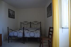 una camera con un letto e una sedia e una finestra di Depandance del Leone di mare a Procida