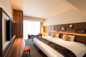 a hotel room with a bed and a television at karaksa hotel premier Tokyo Ginza in Tokyo