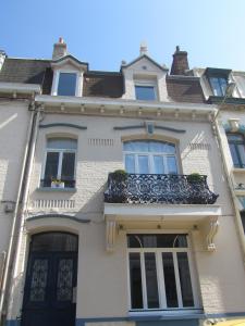 a white house with a balcony on top of it at Chez Marie in Dunkerque