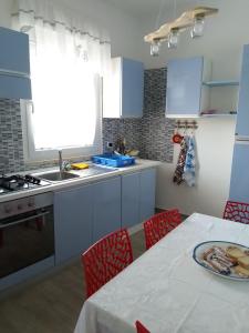 una cocina con armarios azules y una mesa con un plato. en Rosa dei Venti house, en Campomarino