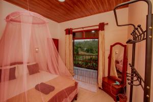 a bedroom with a canopy bed and a window at Ella Breeze Homestay in Ella
