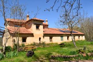 an old house with a picnic table in front of it at Casas Rurales Camino del Castaño in Galaroza