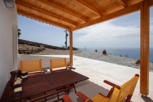 a patio with a table and chairs and a view of the ocean at Natassa's View in Kerames