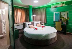 a bedroom with a large bed with green walls at Guesthouse Villa Modex in Paraćin