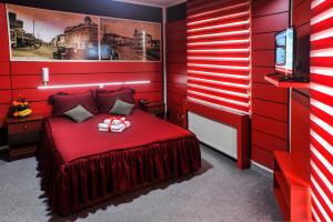 a red bedroom with a bed and a television at Guesthouse Villa Modex in Paraćin