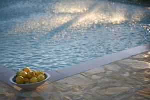 a bowl of fruit sitting next to a swimming pool at Hotel Rural Posada del Moro in Cazalla de la Sierra