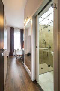 uma casa de banho com um chuveiro e uma porta de vidro em Passion Downtown Suite em Belgrado