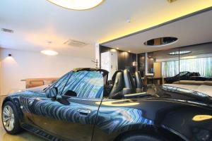 un coche aparcado en una habitación con dormitorio en H Drive Hotel, en Iksan