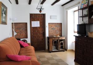a living room with a couch and a television at Apartamentos Maite in Oreña