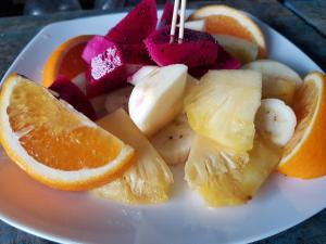 a plate of fruit with orange slices and oranges at Sea House Guest House in Koh Rong Island +15 photos