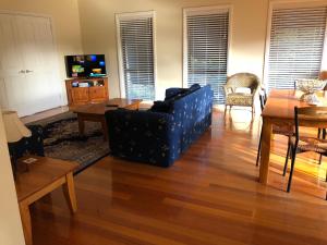 a living room with a couch and a table at Seagrape Cottage in Ocean Grove