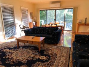 a living room with a couch and a table at Seagrape Cottage in Ocean Grove