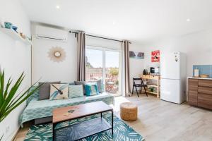 a bedroom with a bed and a refrigerator and a table at La Cassidaine in Cassis