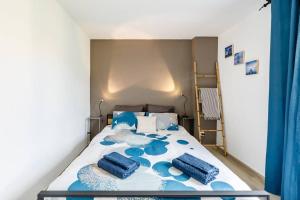 a bedroom with a bed with blue pillows on it at La Cassidaine in Cassis