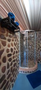 een douche in een kamer met een stenen muur bij Shamba Yetu Mountain Lodge in Maanhaarrand