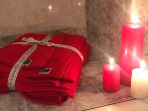 a red towel and two candles on a bathroom counter at Tsina’s apartments in Ágios Nikólaos