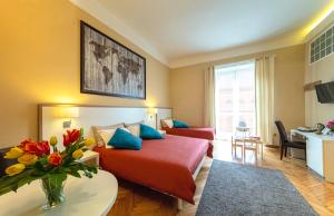 ナポリにあるイル ヴェントレ ディ ナポリのベッドと花のテーブルが備わるホテルルームです。