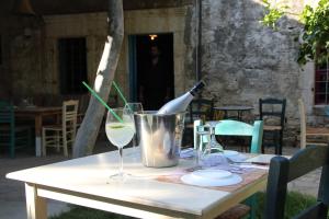 a table with a bottle of wine and two glasses at Olympias Studio "Pitsidia" in Pitsidia