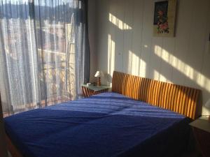 una camera da letto con un letto blu con una finestra di Rossetti 8 a Rapallo