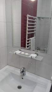 Baño blanco con lavabo y espejo en BeSt Hotel and Restaurant complex, en Dunaivtsi