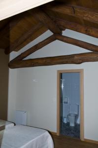 a bedroom with a bed and a bathroom with a toilet at PENSION SERRANO in Sarria