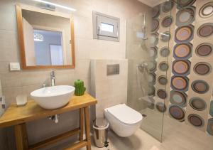 a bathroom with a sink and a toilet and a shower at Ithaka Zante City Villa in Zakynthos Town