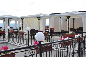 a patio with tables and white tents with flowers at Villa Rosi - Bay View Villas in Kosharitsa