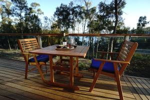 a wooden table and two chairs on a deck at Free Spirit Pods in Barnes Bay