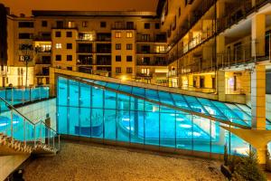 a large swimming pool in a city at night at A11 Apartments & SPA Dermique in Krakow